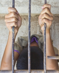 Man holding jail bars