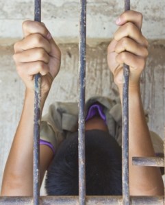 Man holding jail bars